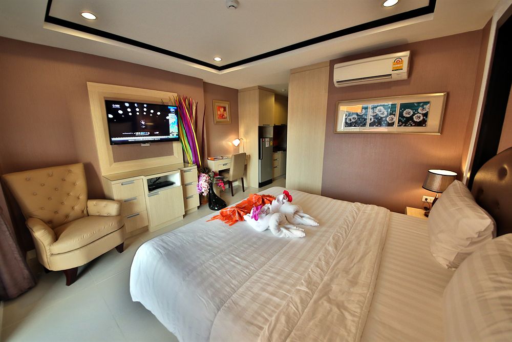 Furnished guest room with a bed, armchair, and built-in furnishings.